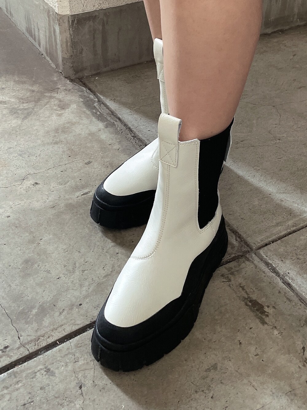 ホワイト系のニット/セーター、ホワイト系のブーツを着用したレディースの冬コーディネートの7枚目の写真