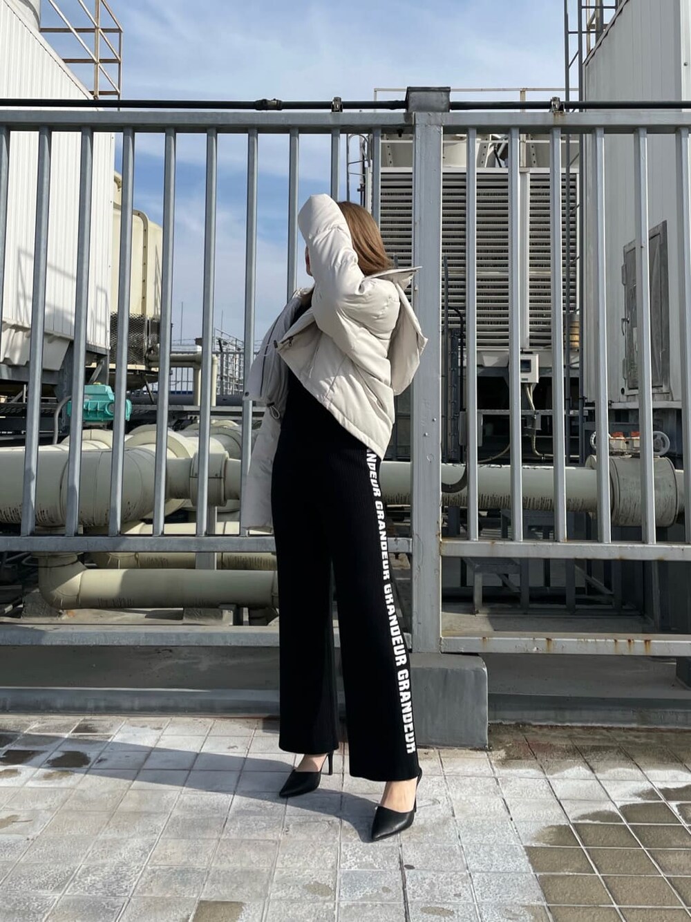 ブラック系のパンプス、ホワイト系のダウンジャケット/コート、ブラック系のその他パンツを着用したレディースの冬コーディネートの2枚目の写真