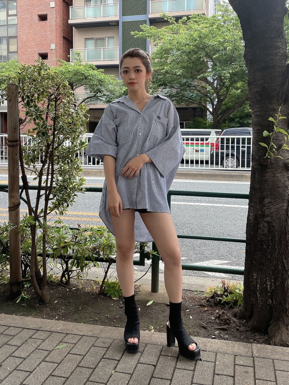 ブルー系のシャツ/ブラウス、ブラック系のブーツを着用したレディースの夏コーディネートの2枚目の写真