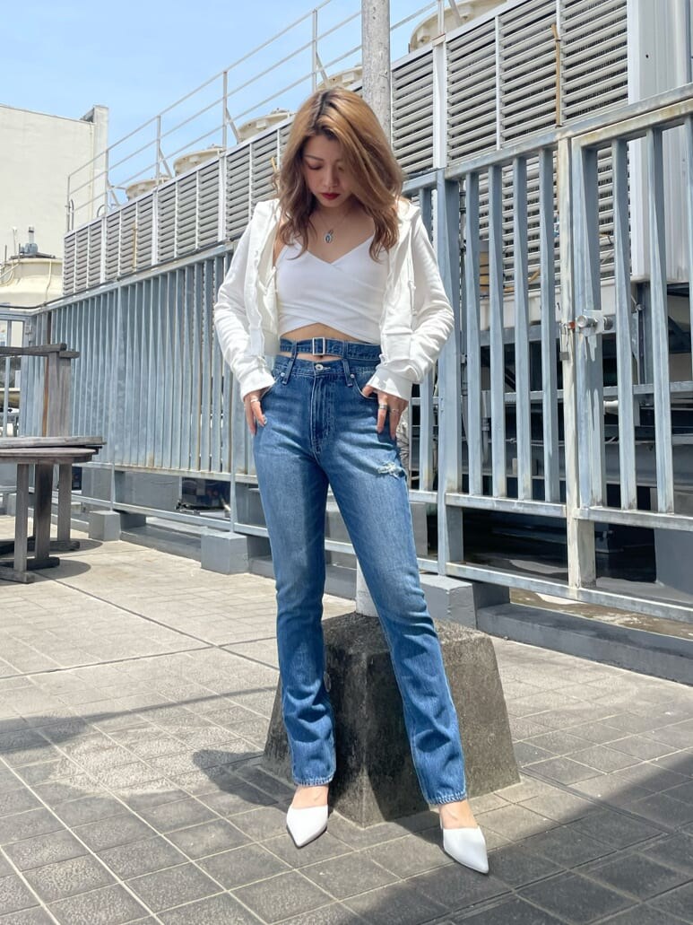 ホワイト系のパンプス、ブルー系のデニムパンツ、ホワイト系のパーカーを着用したレディースの夏コーディネートの5枚目の写真