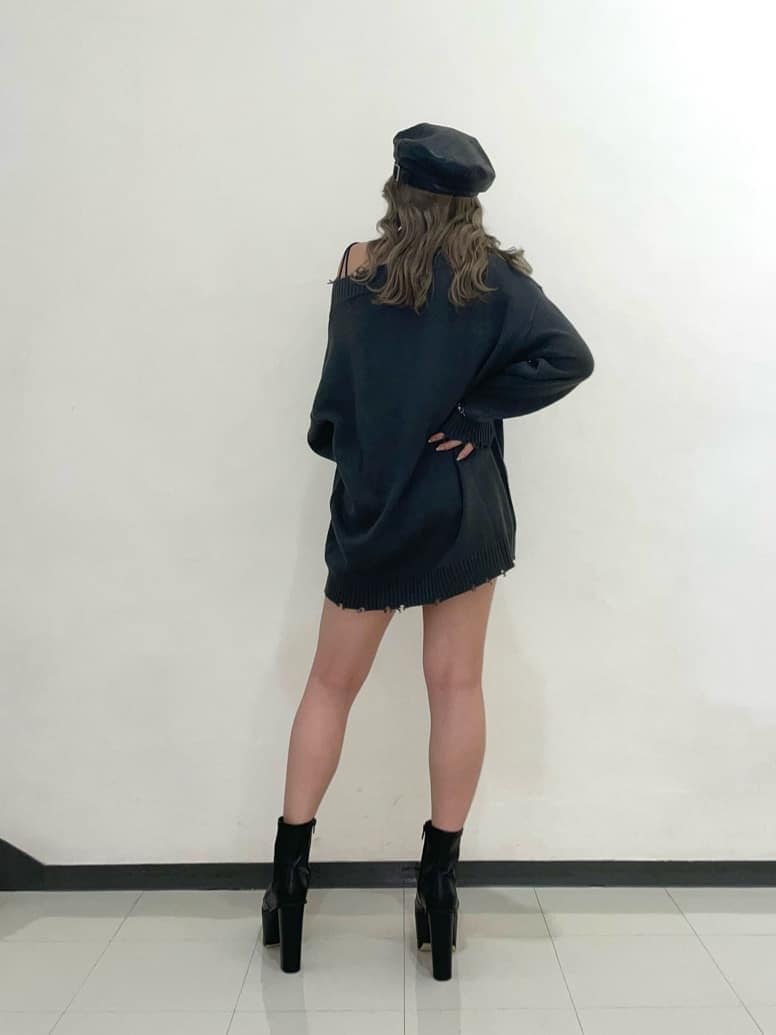 グレー系のニット/セーター、ブルー系のデニムパンツ、ブラック系のブーツを着用したレディースの夏コーディネートの3枚目の写真