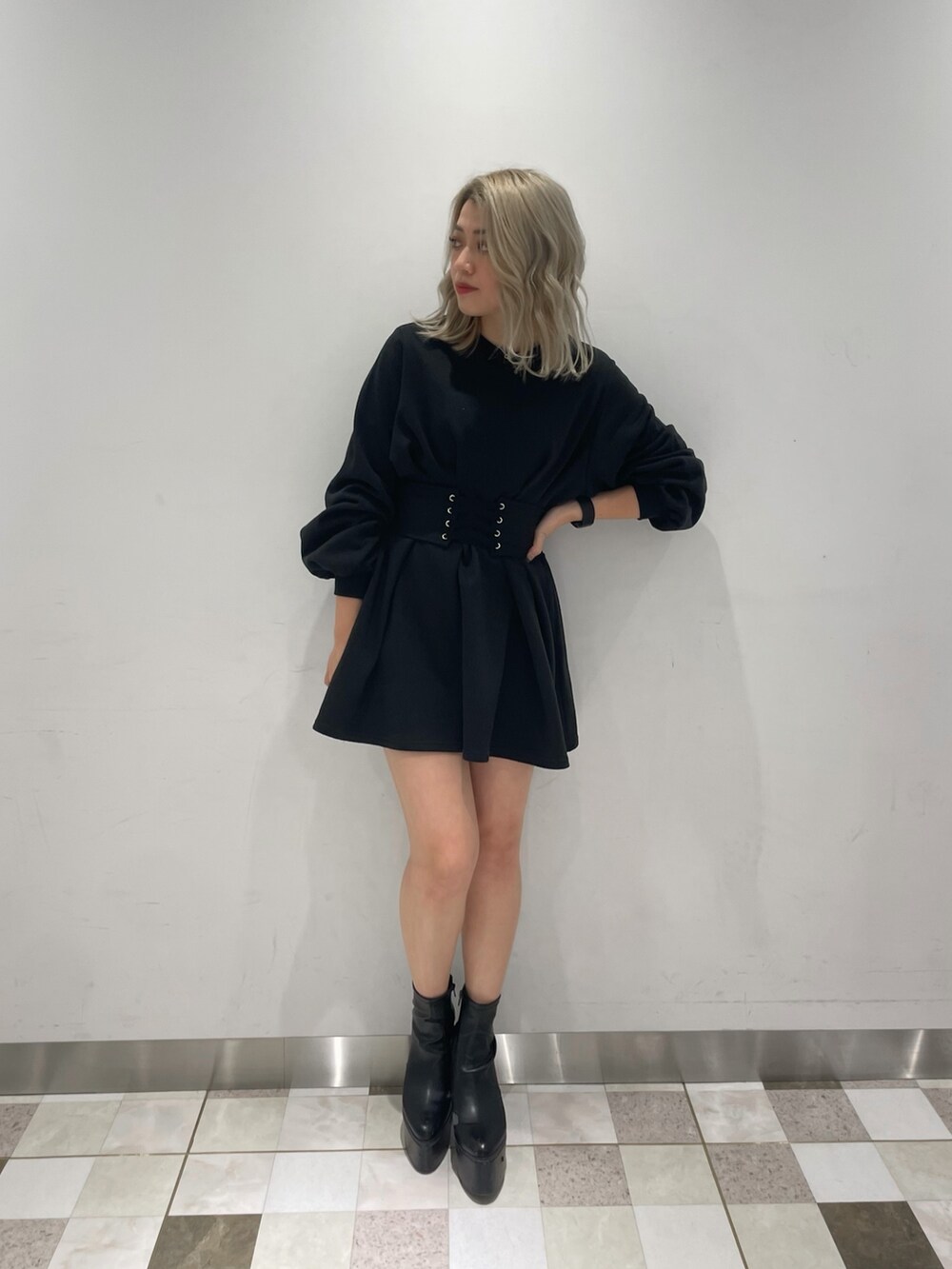 ブラック系のワンピース、ブラック系のブーツ、ホワイト系のダウンジャケット/コートを着用したレディースの冬コーディネートの4枚目の写真