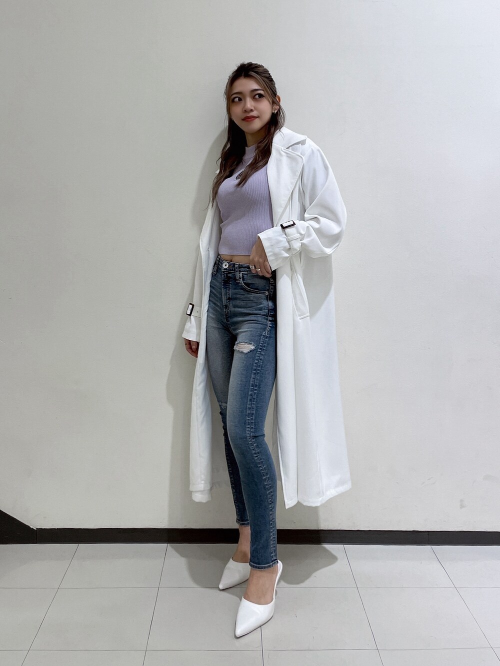ホワイト系のトレンチコート、ブルー系のデニムパンツ、ホワイト系のパンプスを着用したレディースの春コーディネートの2枚目の写真