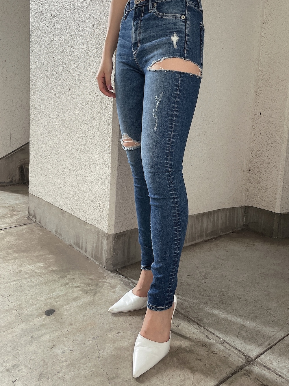 ブルー系のデニムパンツ、ホワイト系のニット/セーター、ホワイト系のパンプスを着用したレディースの夏コーディネートの6枚目の写真