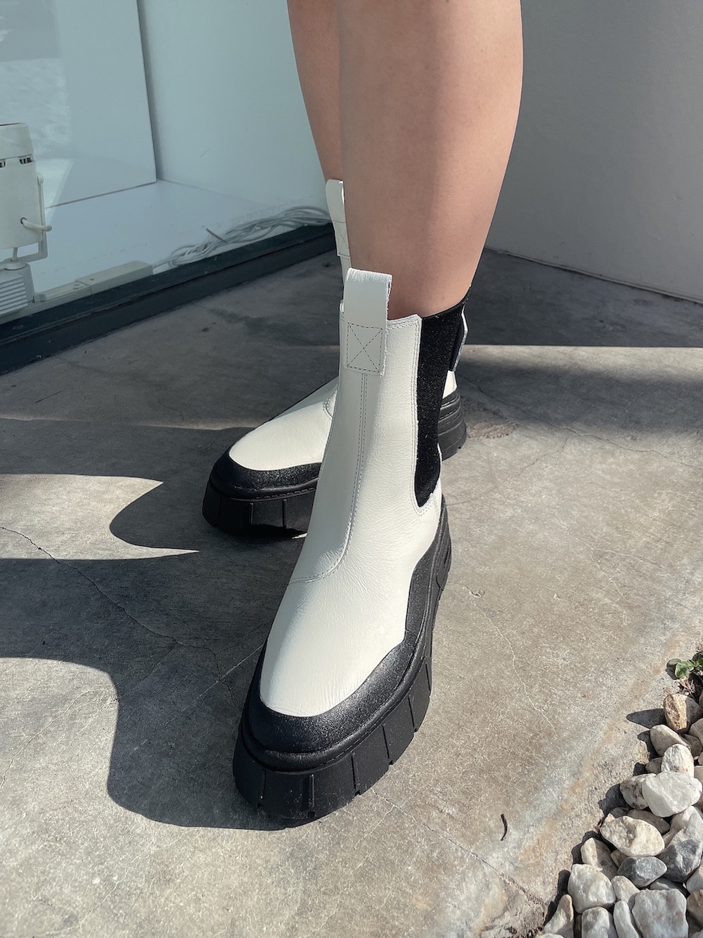 ブラック系のTシャツ/カットソー、ホワイト系のブーツ、ホワイト系のニットキャップ/ビーニーを着用したレディースの冬コーディネートの9枚目の写真