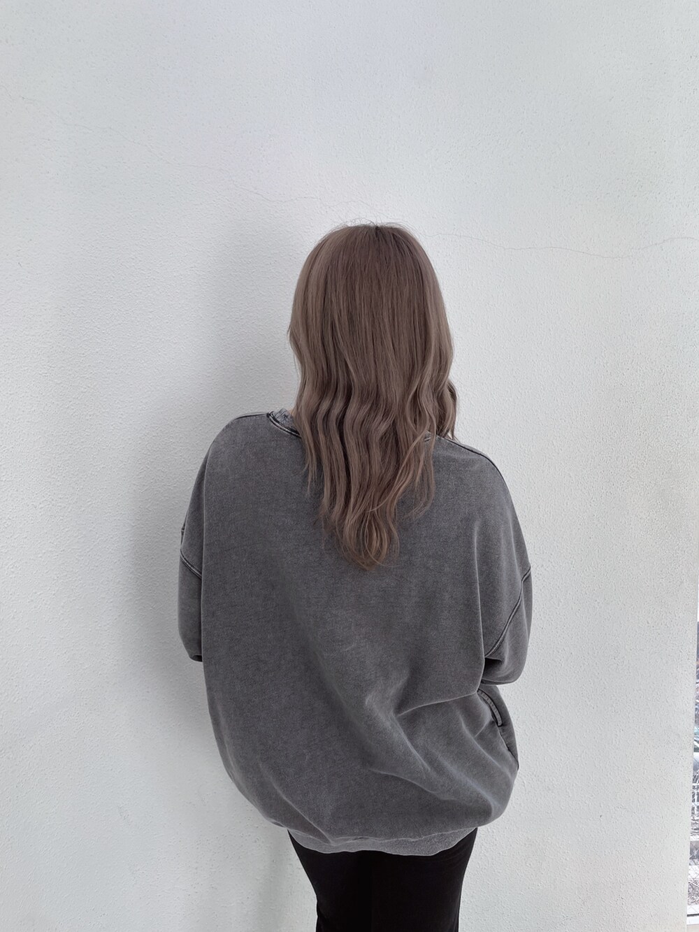 グレー系のスウェット、ブラック系のスウェットパンツ、ブラック系のパンプスを着用したレディースの冬コーディネートの5枚目の写真