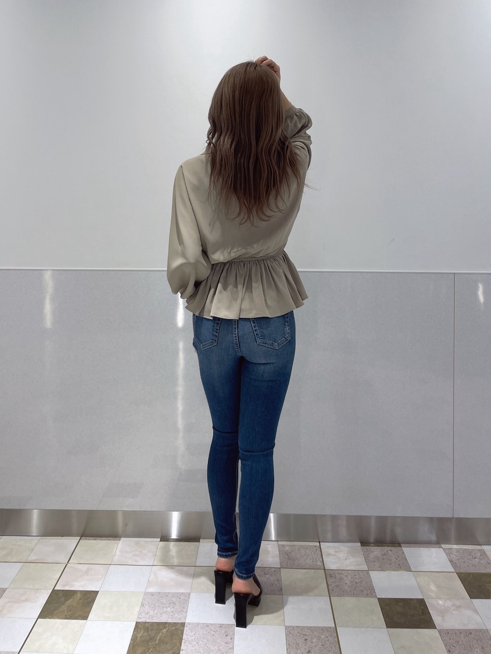 ベージュ系のシャツ/ブラウス、ブルー系のデニムパンツ、ブラック系のパンプスを着用したレディースの冬コーディネートの3枚目の写真