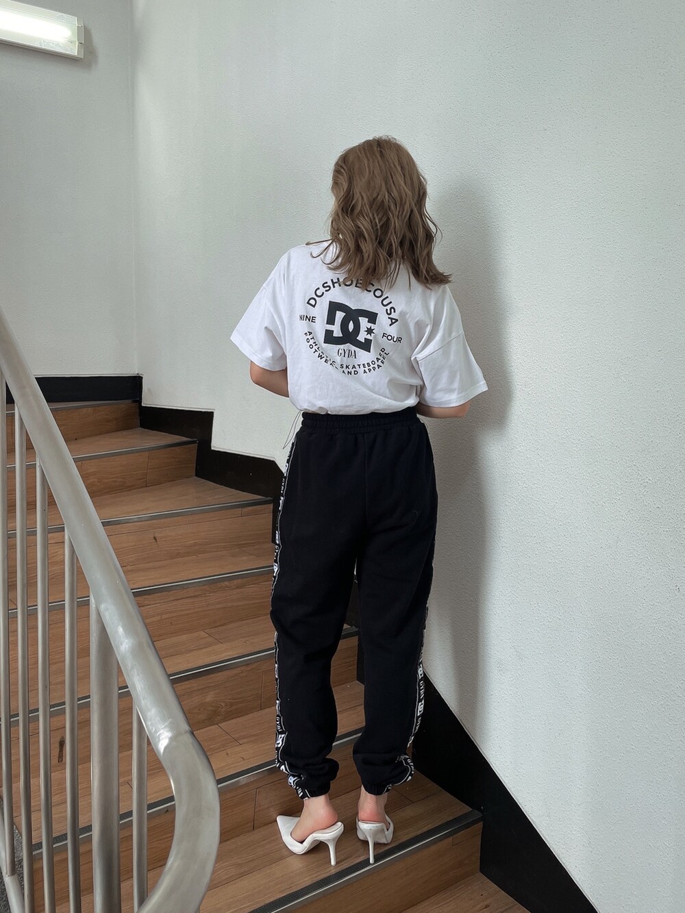 ホワイト系のTシャツ/カットソー、ブラック系のスウェットパンツ、ホワイト系のパンプスを着用したレディースの春コーディネートの3枚目の写真