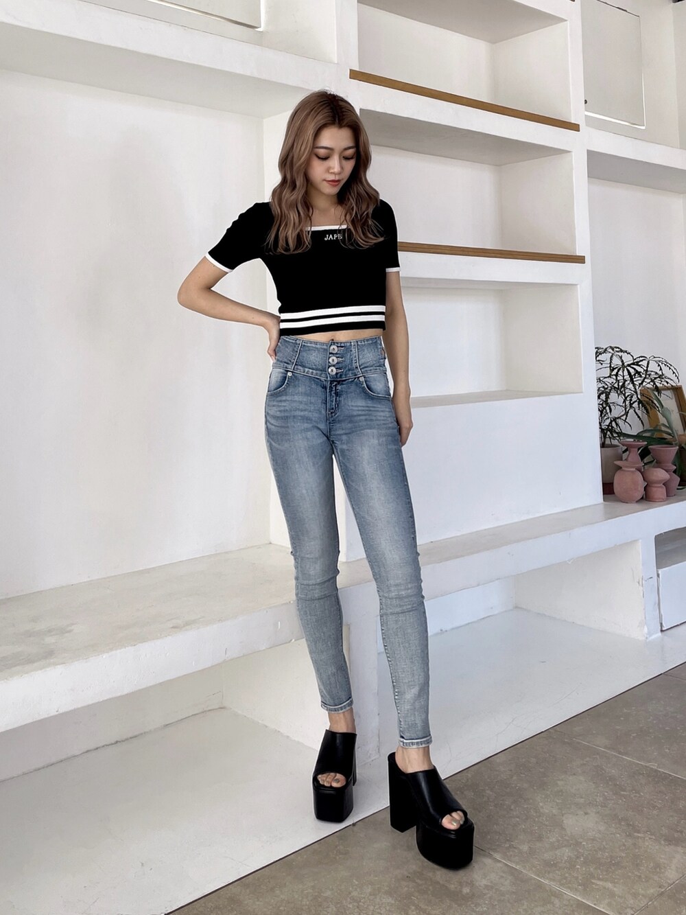 ブラック系のサンダル、ブルー系のデニムパンツ、ブラック系のニット/セーターを着用したレディースの春コーディネートの2枚目の写真