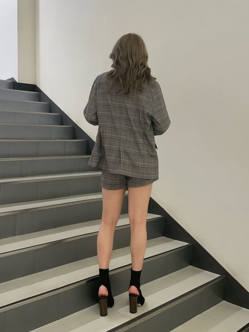 ブラック系のブーツ、ブラック系のキャミソール、ベージュ系のテーラードジャケットを着用したレディースの夏コーディネートの4枚目の写真