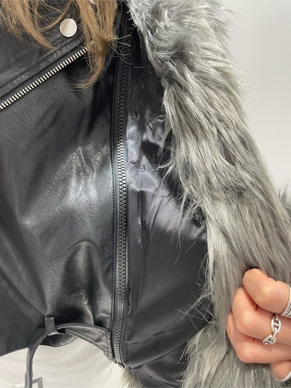 ブラック系のブーツ、グレー系のライダースジャケット、ホワイト系のワンピースを着用したレディースの秋コーディネートの9枚目の写真