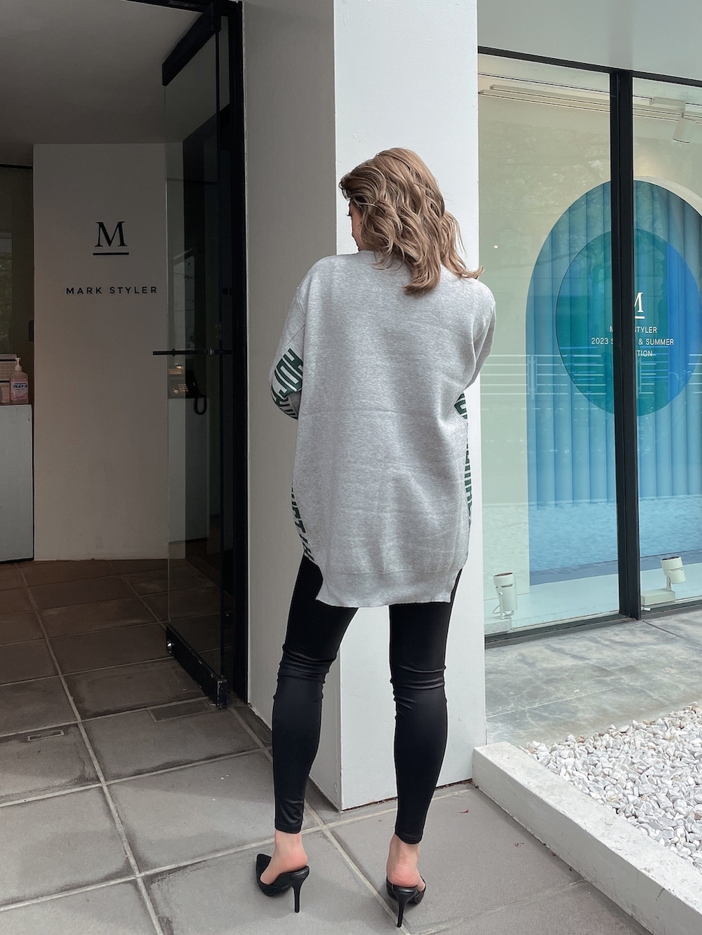 グレー系のニット/セーター、ブラック系のその他パンツ、ブラック系のパンプスを着用したレディースの春コーディネートの2枚目の写真