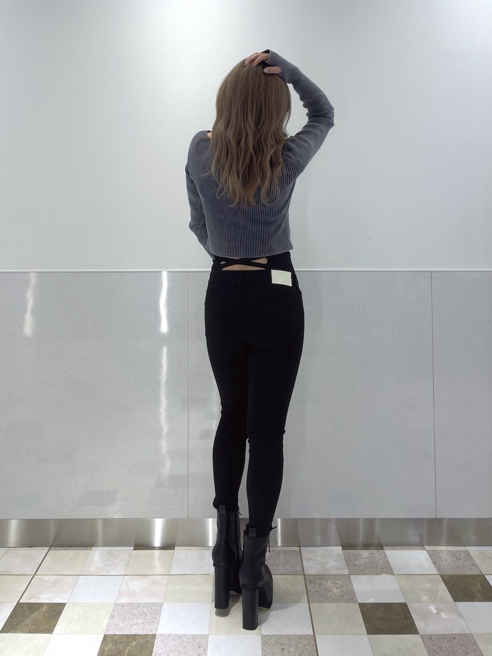 ブルー系のニット/セーター、ブラック系のデニムパンツ、ブラック系のブーツを着用したレディースの冬コーディネートの2枚目の写真