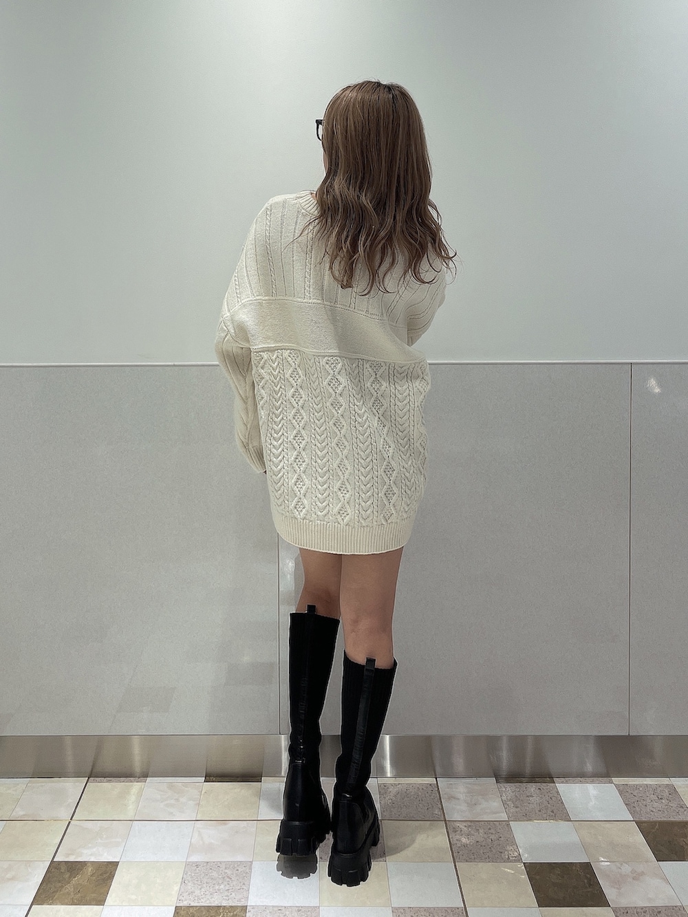 ホワイト系のニット/セーター、ブラック系のブーツを着用したレディースの秋コーディネートの3枚目の写真