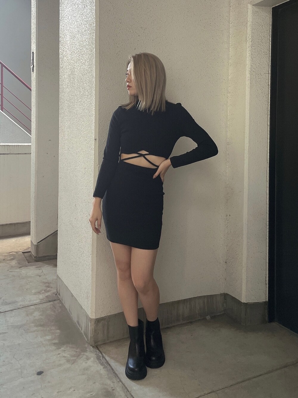 グリーン系のダウンジャケット/コート、ブラック系のワンピース、ブラック系のブーツを着用したレディースの秋コーディネートの3枚目の写真