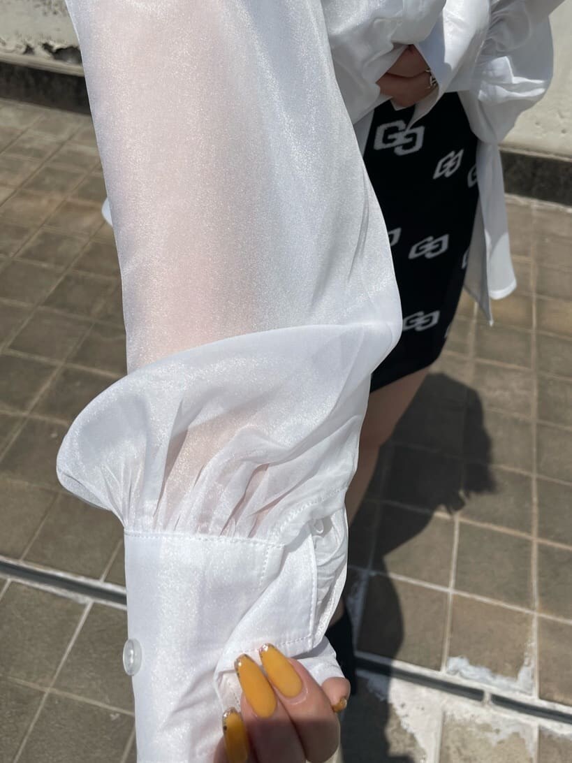 ブラック系のパンプス、ブラック系のワンピース、ホワイト系のシャツ/ブラウスを着用したレディースの春コーディネートの7枚目の写真