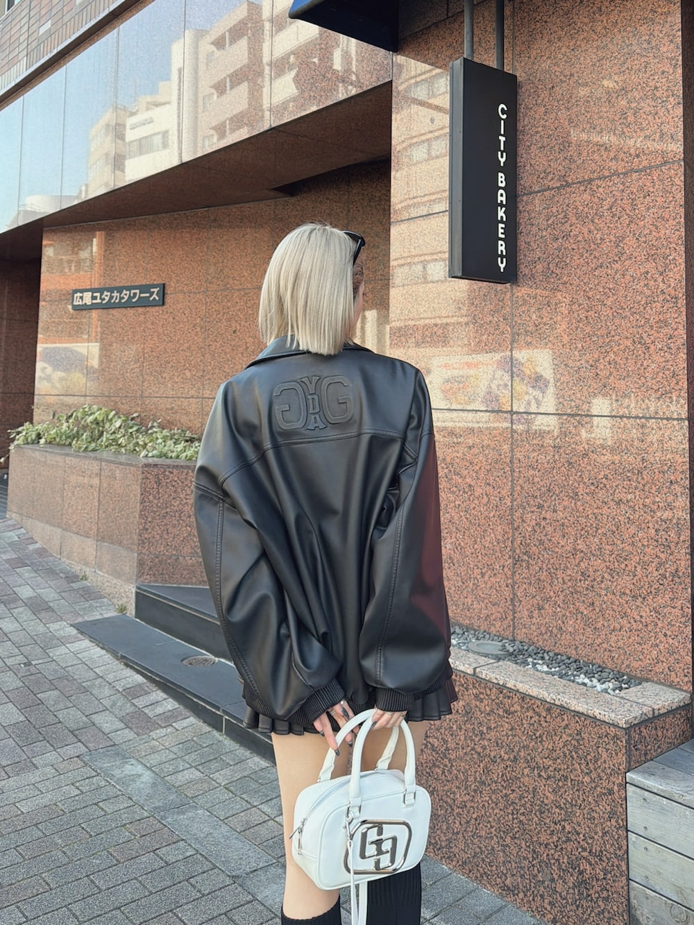 ブラック系のブルゾン、ブラック系のスカート、ブラック系のブーツを着用したレディースの冬コーディネートの5枚目の写真