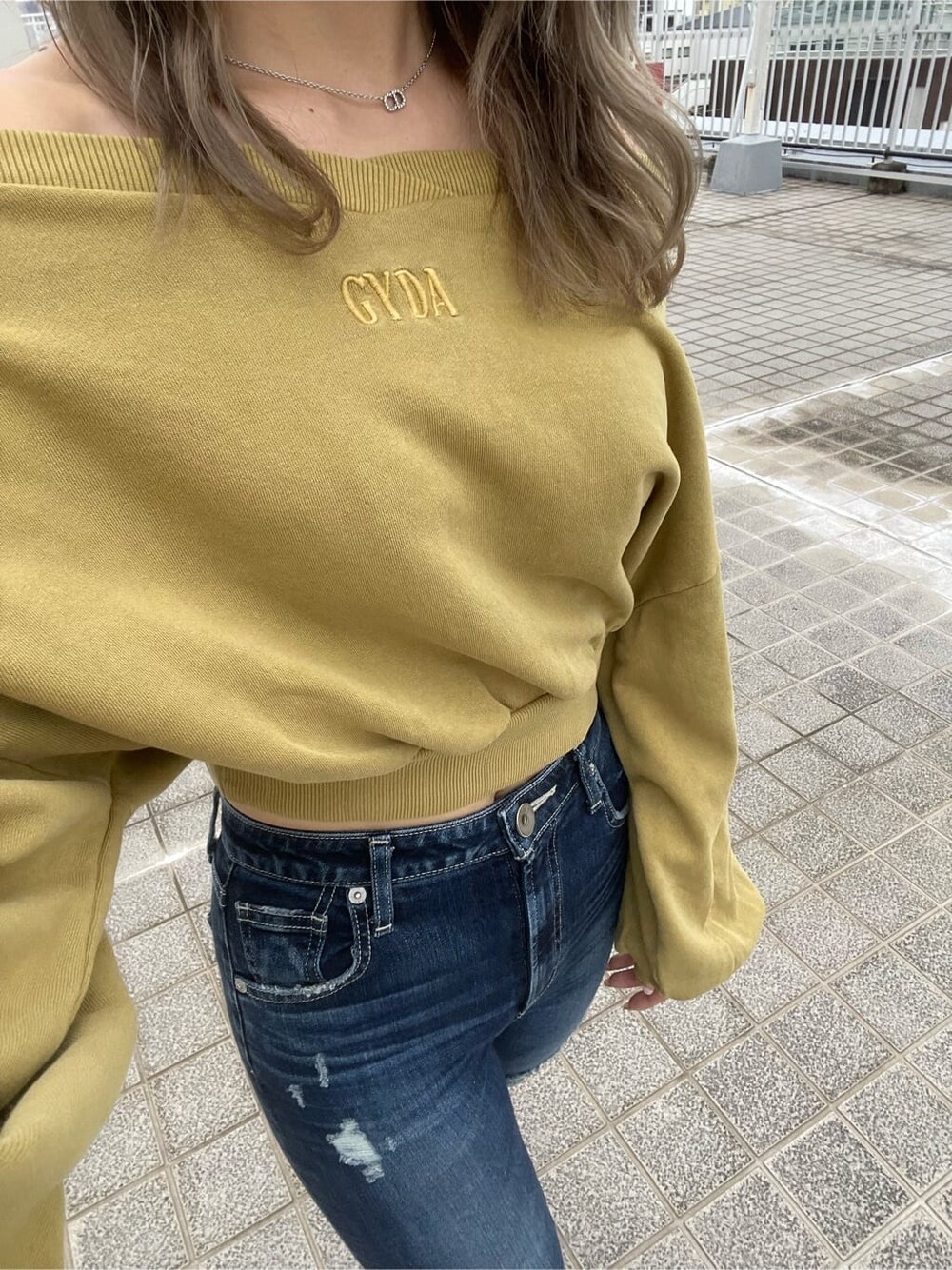 ブラック系のパンプス、イエロー系のスウェット、ブルー系のデニムパンツを着用したレディースの夏コーディネートの4枚目の写真