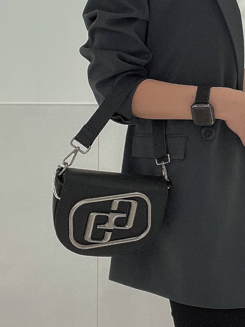 ブラック系のブーツ、ブラック系のデニムパンツ、ブラック系のハンドバッグを着用したレディースの秋コーディネートの7枚目の写真