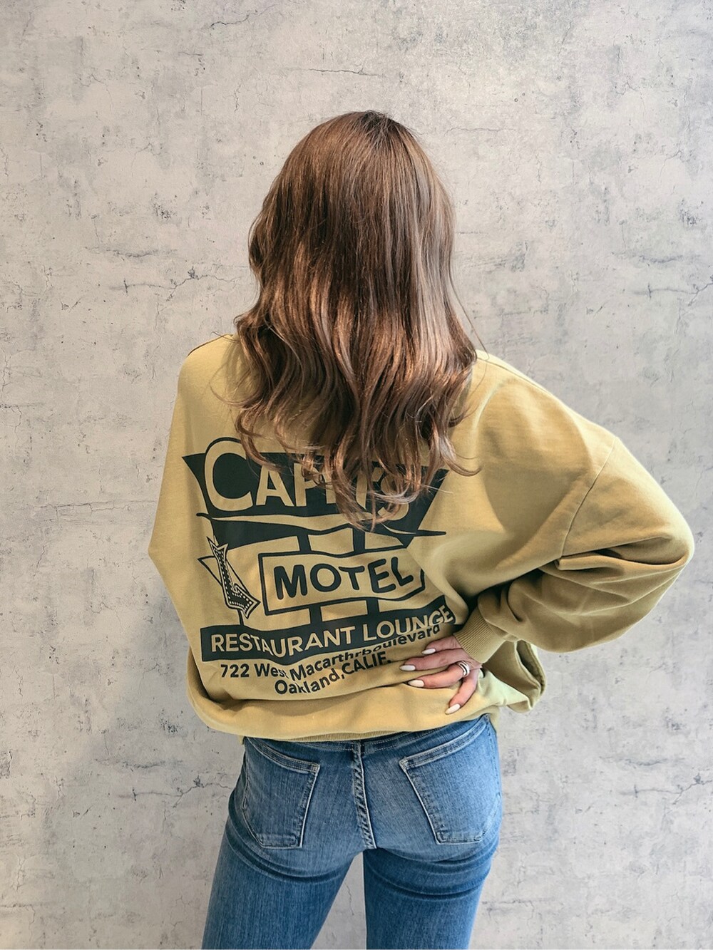 ホワイト系のパンプス、ブルー系のデニムパンツ、イエロー系のスウェットを着用したレディースの冬コーディネートの3枚目の写真