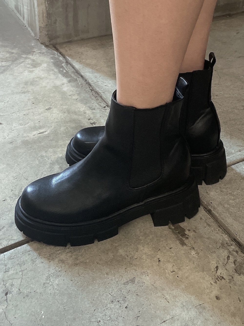 グリーン系のダウンジャケット/コート、ブラック系のワンピース、ブラック系のブーツを着用したレディースの秋コーディネートの8枚目の写真