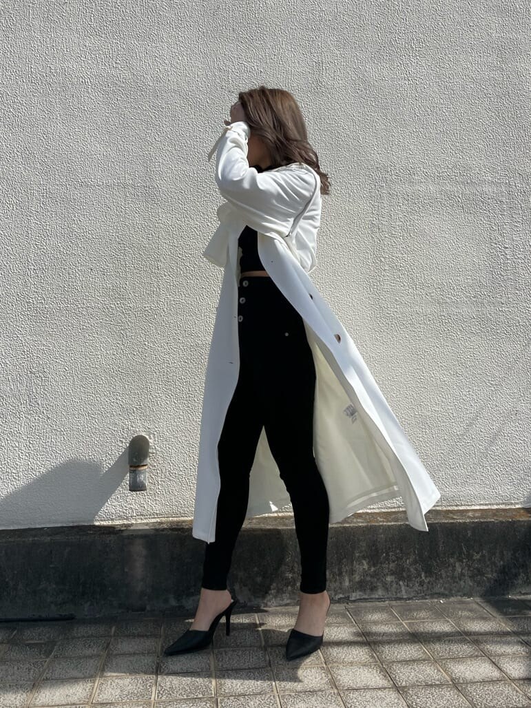 ブラック系のパンプス、ホワイト系のトレンチコートを着用したレディースの春コーディネートの5枚目の写真