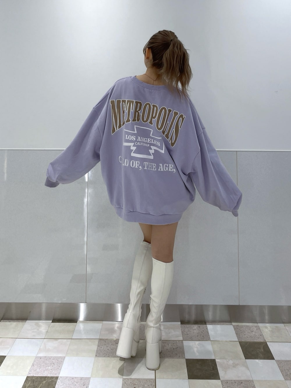 パープル系のスウェット、ホワイト系のブーツを着用したレディースの冬コーディネートの2枚目の写真