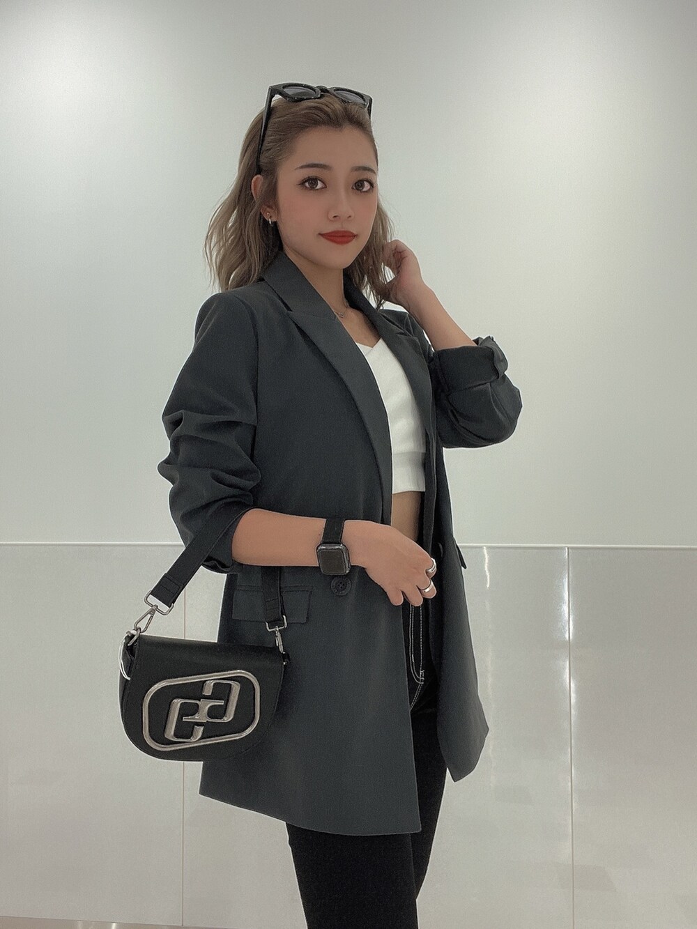 ブラック系のブーツ、ブラック系のデニムパンツ、ブラック系のハンドバッグを着用したレディースの秋コーディネートの3枚目の写真