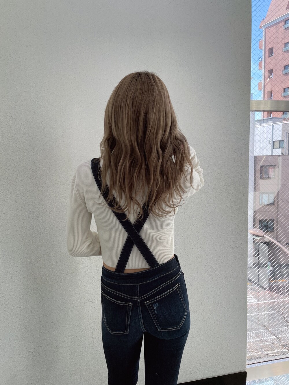 ホワイト系のカーディガン/ボレロ、ブルー系のつなぎ/オールインワン、ホワイト系のパンプスを着用したレディースの冬コーディネートの4枚目の写真