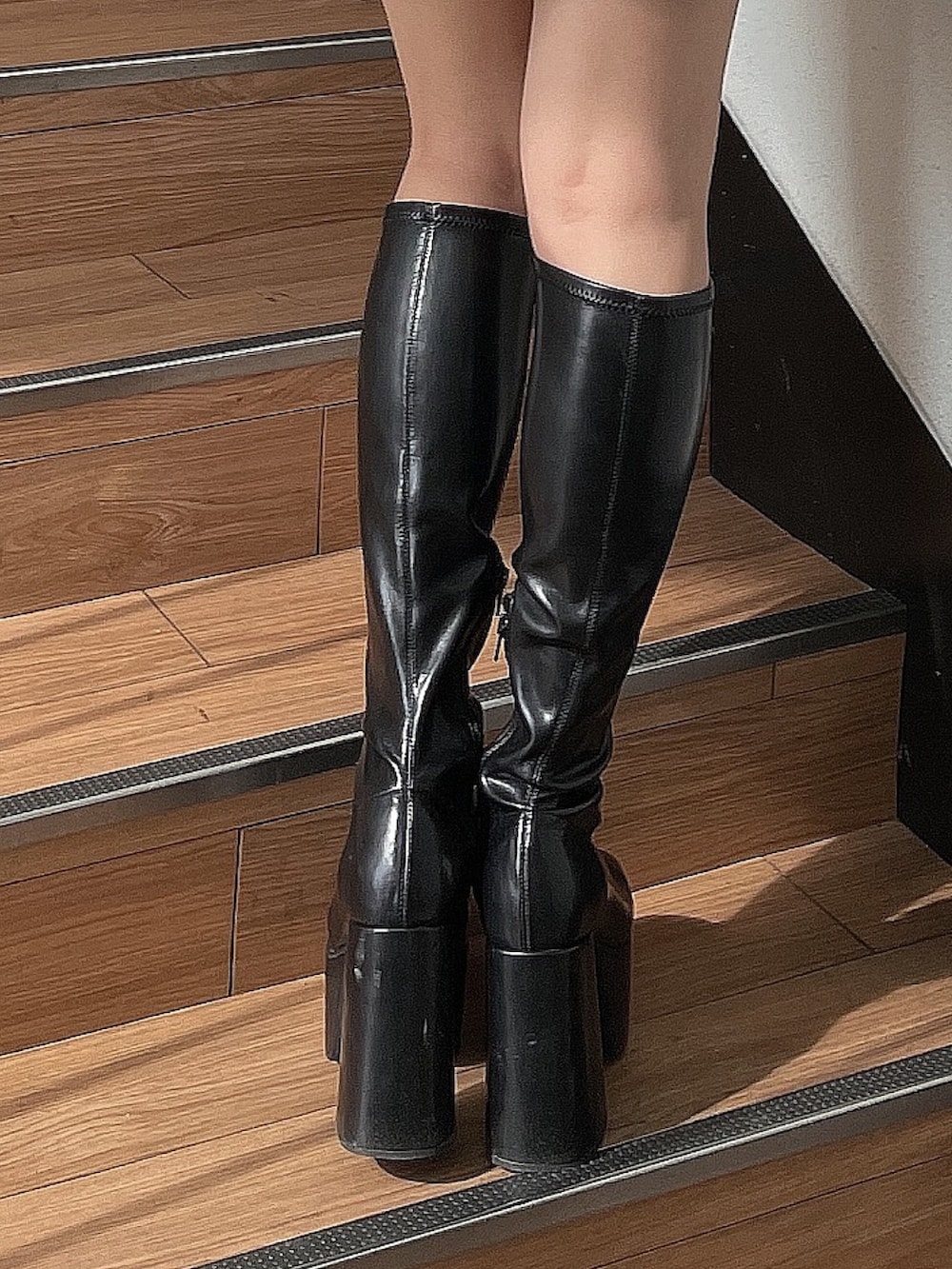 ブラック系のニット/セーター、ブラック系のブルゾン、ブラック系のブーツを着用したレディースの秋コーディネートの7枚目の写真