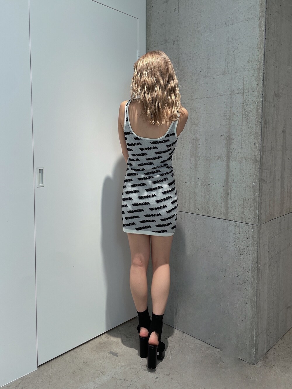 ホワイト系のワンピース、ブラック系のブーツを着用したレディースの夏コーディネートの2枚目の写真