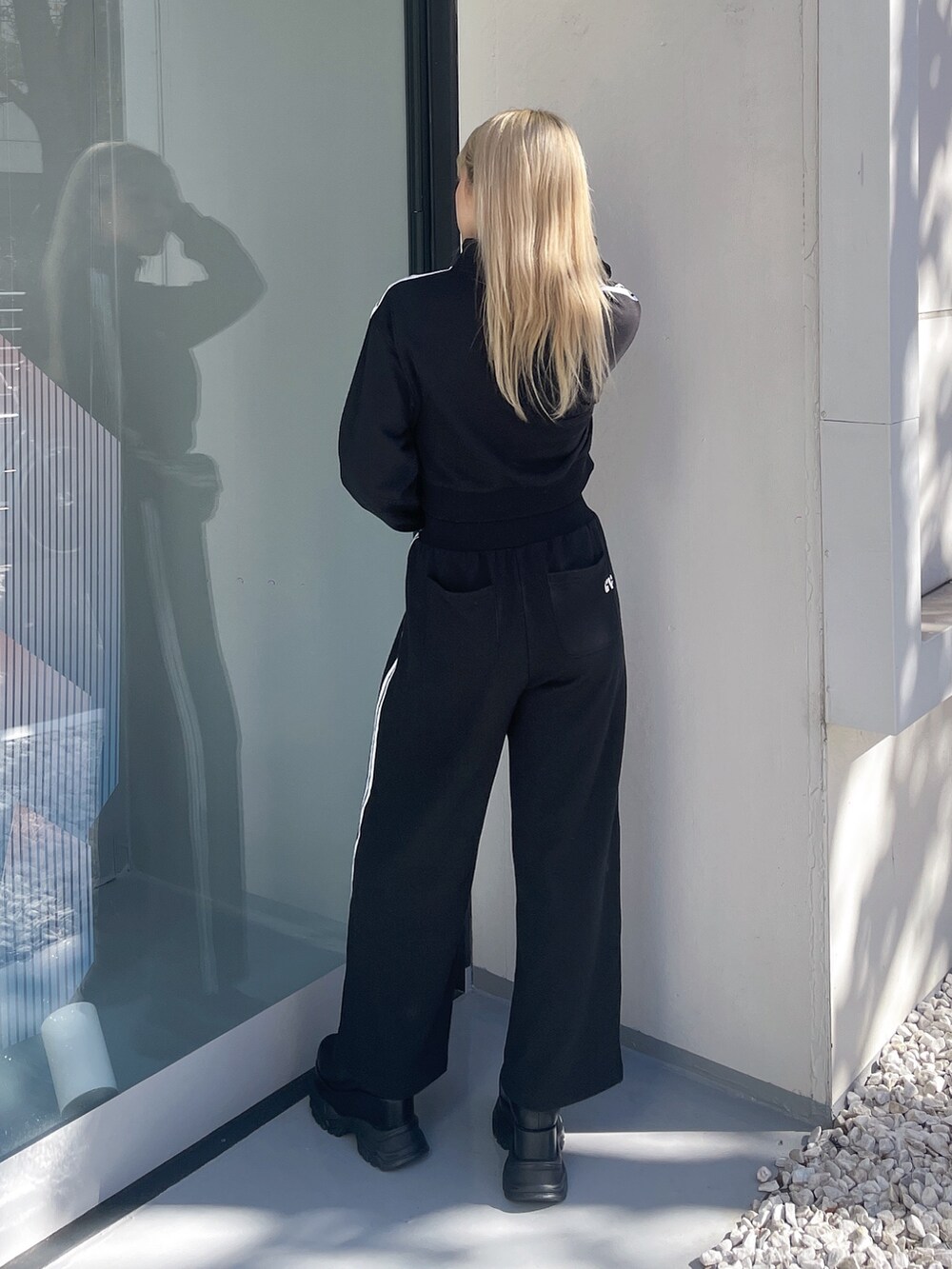 ブラック系のカーディガン/ボレロ、ブラック系のその他パンツ、ブラック系のブーツを着用したレディースの秋コーディネートの2枚目の写真