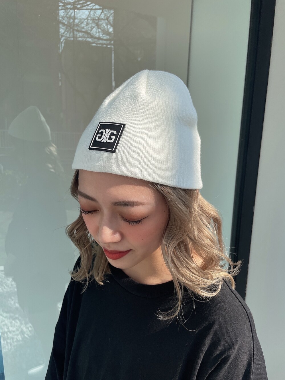 ブラック系のTシャツ/カットソー、ホワイト系のブーツ、ホワイト系のニットキャップ/ビーニーを着用したレディースの冬コーディネートの8枚目の写真