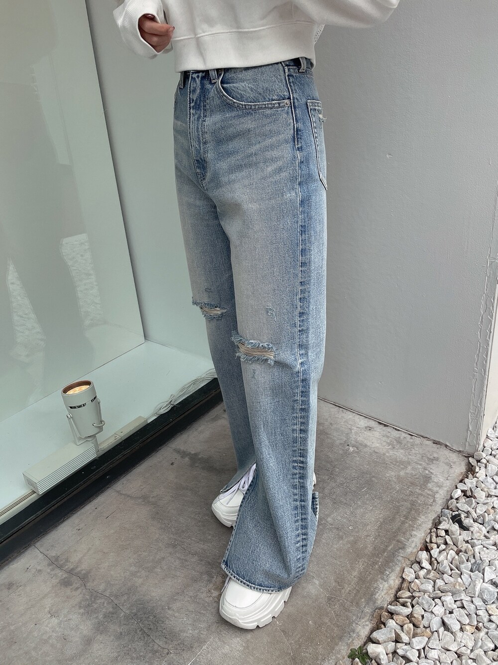 ホワイト系のスウェット、ブルー系のデニムパンツ、ホワイト系のスニーカーを着用したレディースの冬コーディネートの6枚目の写真