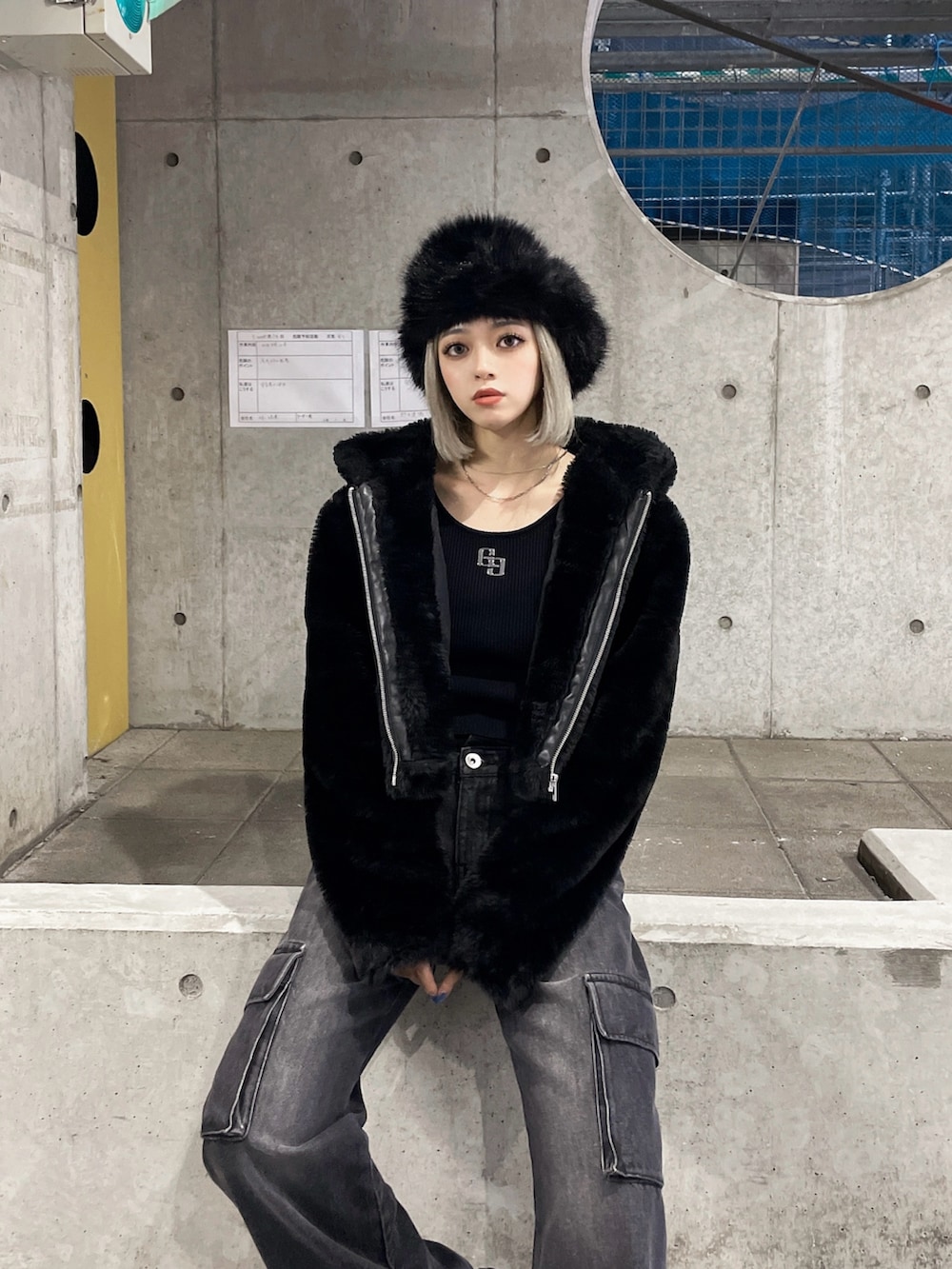 ブラック系のブルゾン、ブラック系のニット/セーター、ブラック系のデニムパンツを着用したレディースの秋コーディネートの5枚目の写真