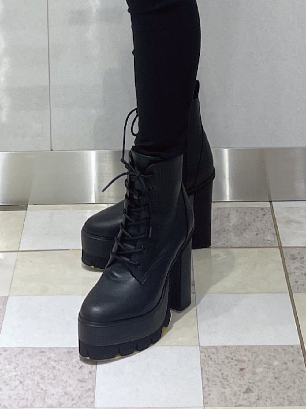 ブルー系のニット/セーター、ブラック系のデニムパンツ、ブラック系のブーツを着用したレディースの冬コーディネートの7枚目の写真