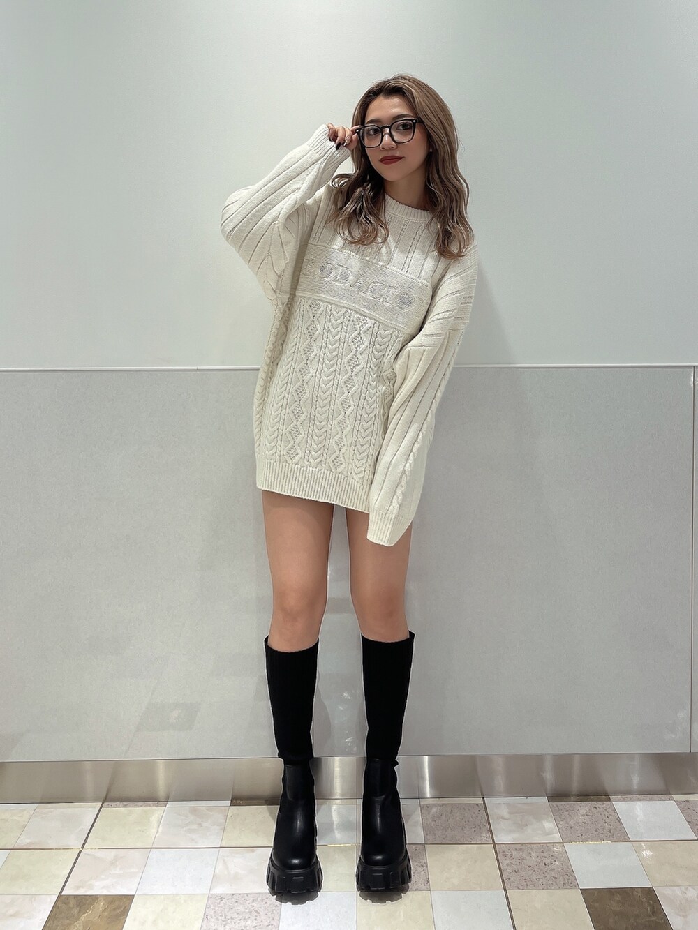 ホワイト系のニット/セーター、ブラック系のブーツを着用したレディースの秋コーディネートの2枚目の写真