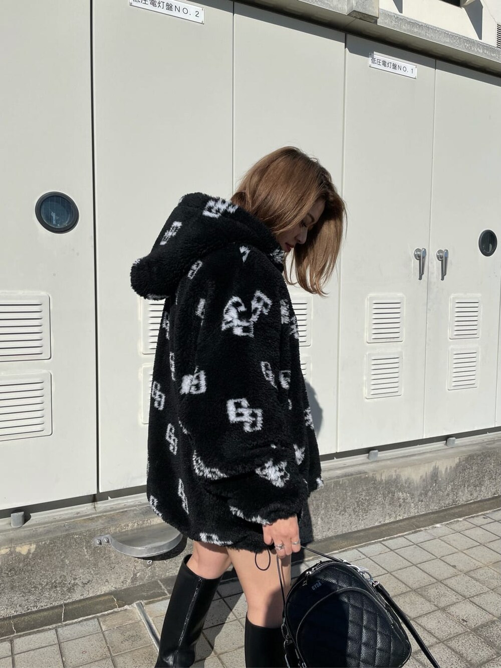 ブラック系のニット/セーター、ブラック系のブーツ、ブラック系のスカートを着用したレディースの秋コーディネートの5枚目の写真