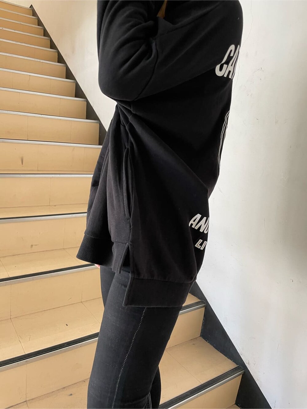 グレー系のパーカー、ブラック系のブーツ、ホワイト系のTシャツ/カットソーを着用したレディースの冬コーディネートの6枚目の写真