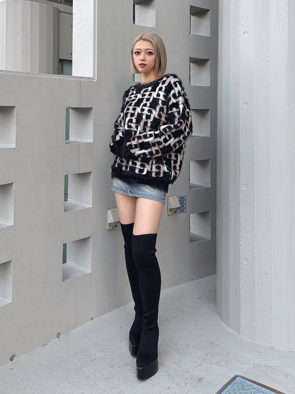 ブラック系のニット/セーター、ブラック系のブーツを着用したレディースの冬コーディネートの3枚目の写真