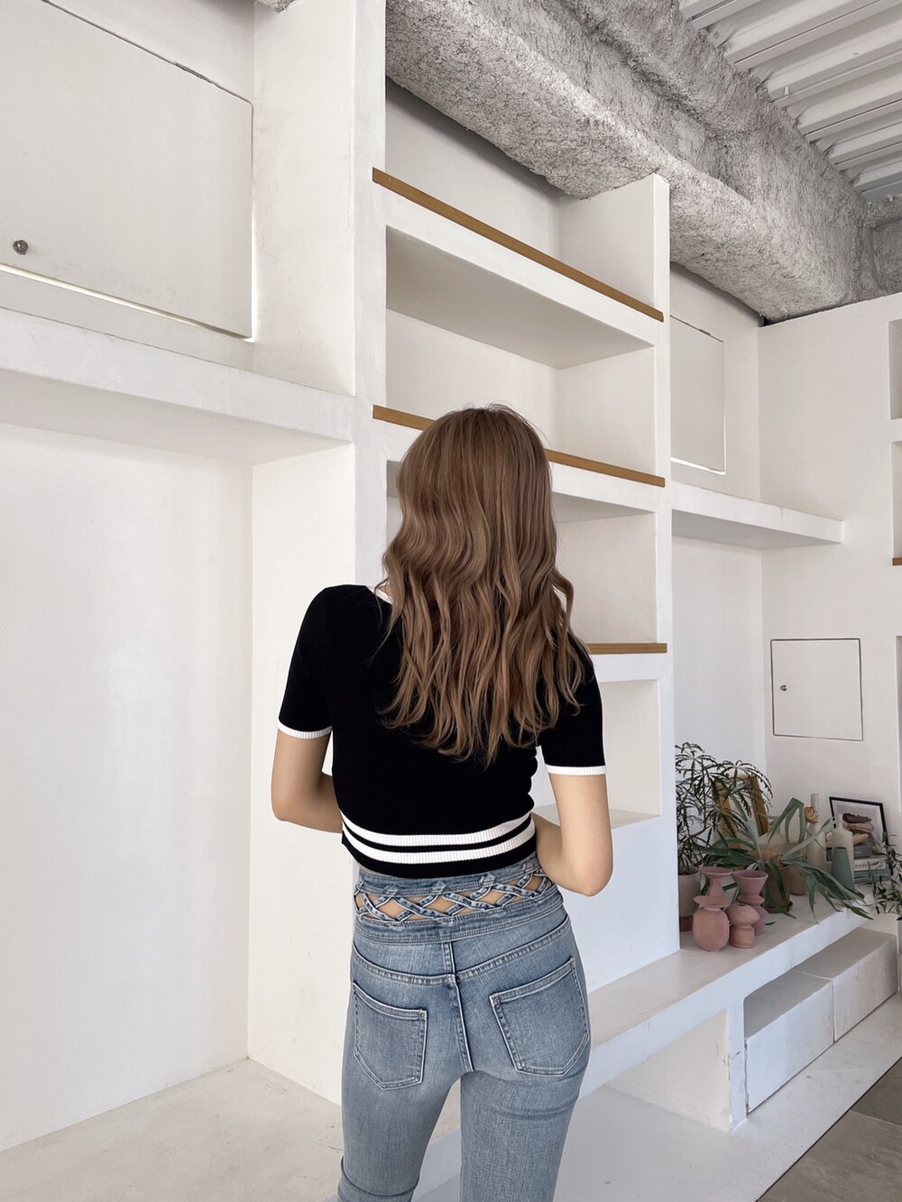 ブラック系のサンダル、ブルー系のデニムパンツ、ブラック系のニット/セーターを着用したレディースの春コーディネートの6枚目の写真