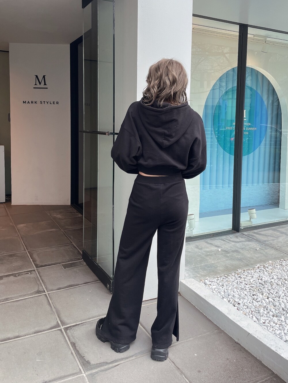 ブラック系のパーカー、ブラック系のスウェットパンツ、ブラック系のスニーカーを着用したレディースの冬コーディネートの3枚目の写真