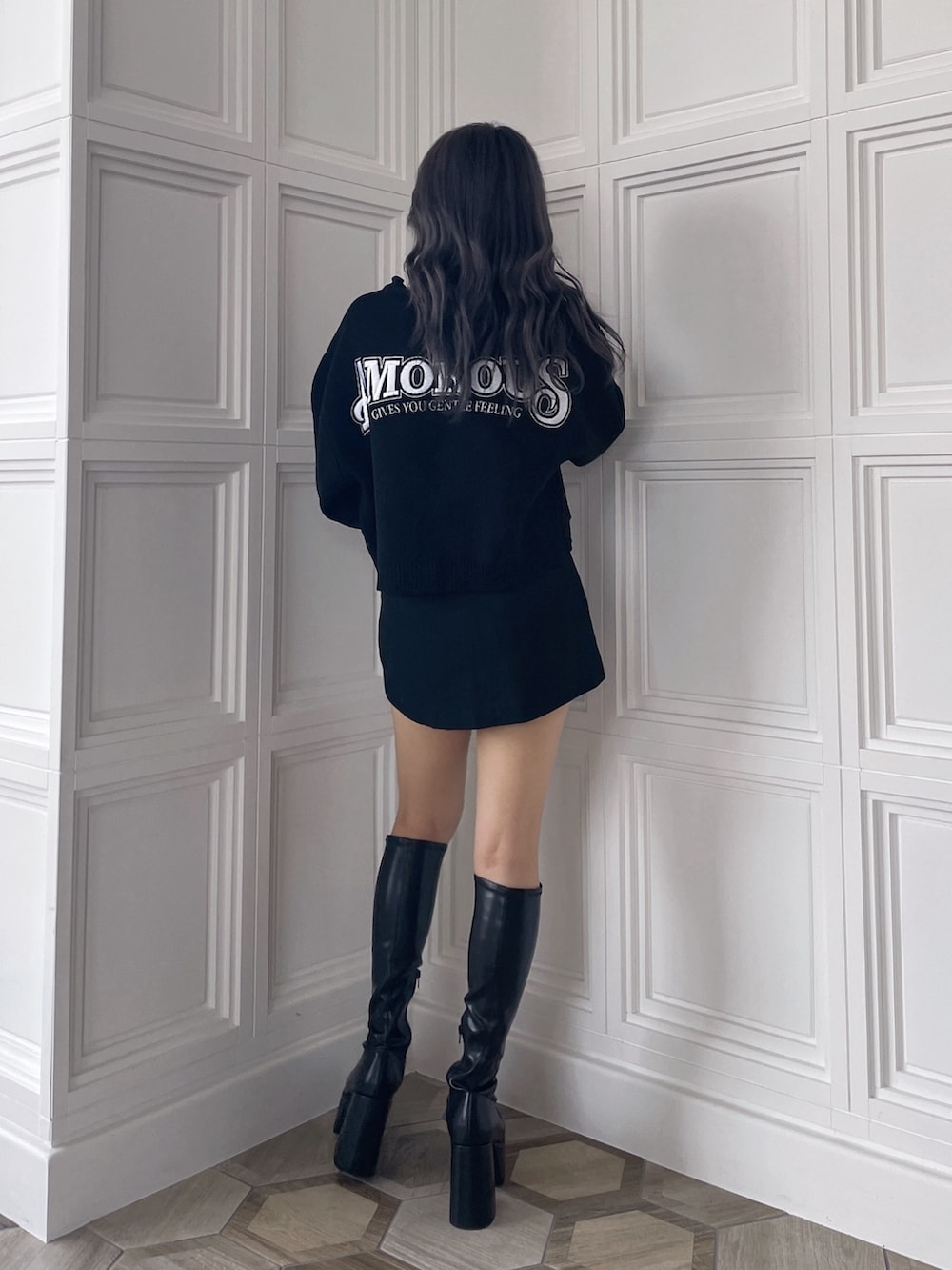 ブラック系のニット/セーター、ブラック系のスカート、ブラック系のブーツを着用したレディースの秋コーディネートの3枚目の写真