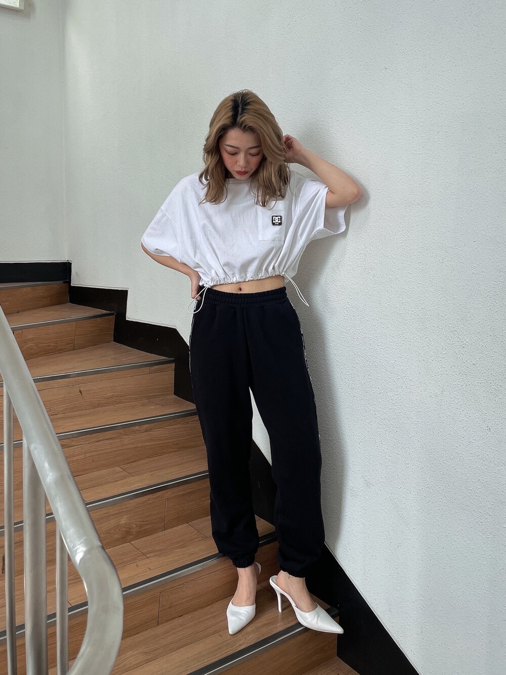ホワイト系のTシャツ/カットソー、ブラック系のスウェットパンツ、ホワイト系のパンプスを着用したレディースの春コーディネートの4枚目の写真