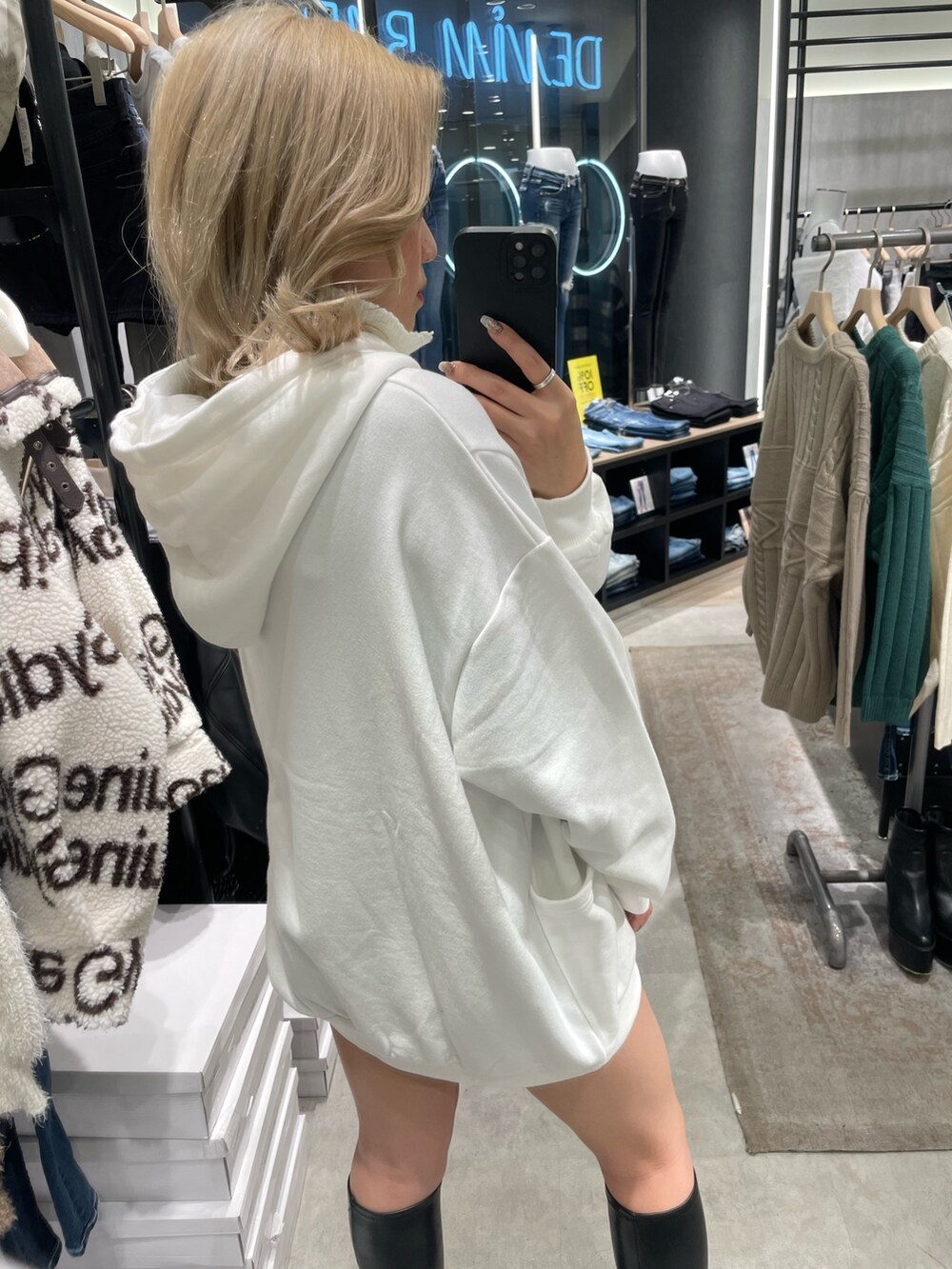 ホワイト系のスウェット、ブラック系のブーツを着用したレディースの秋コーディネートの3枚目の写真