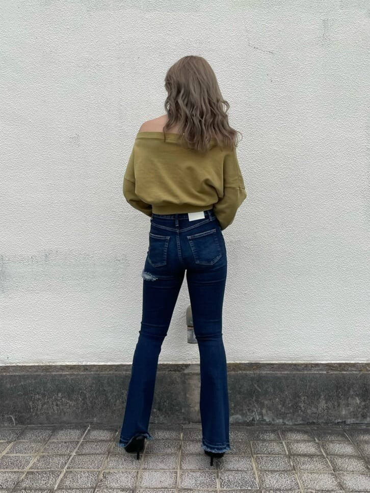 ブラック系のパンプス、イエロー系のスウェット、ブルー系のデニムパンツを着用したレディースの夏コーディネートの2枚目の写真