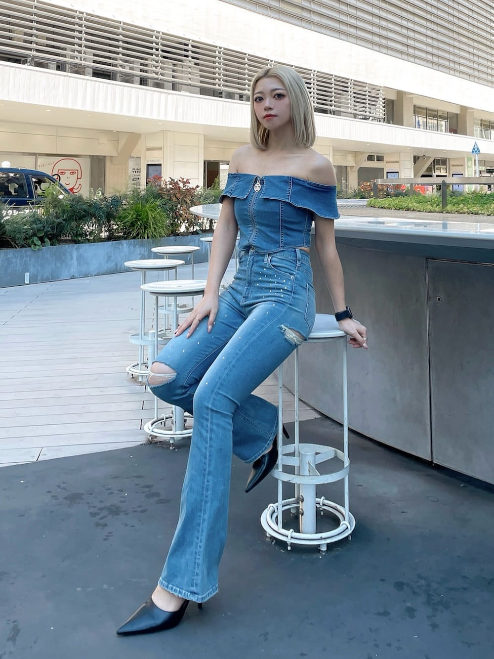 ブルー系のTシャツ/カットソー、ブルー系のデニムパンツ、ブラック系のパンプスを着用したレディースの冬コーディネートの2枚目の写真