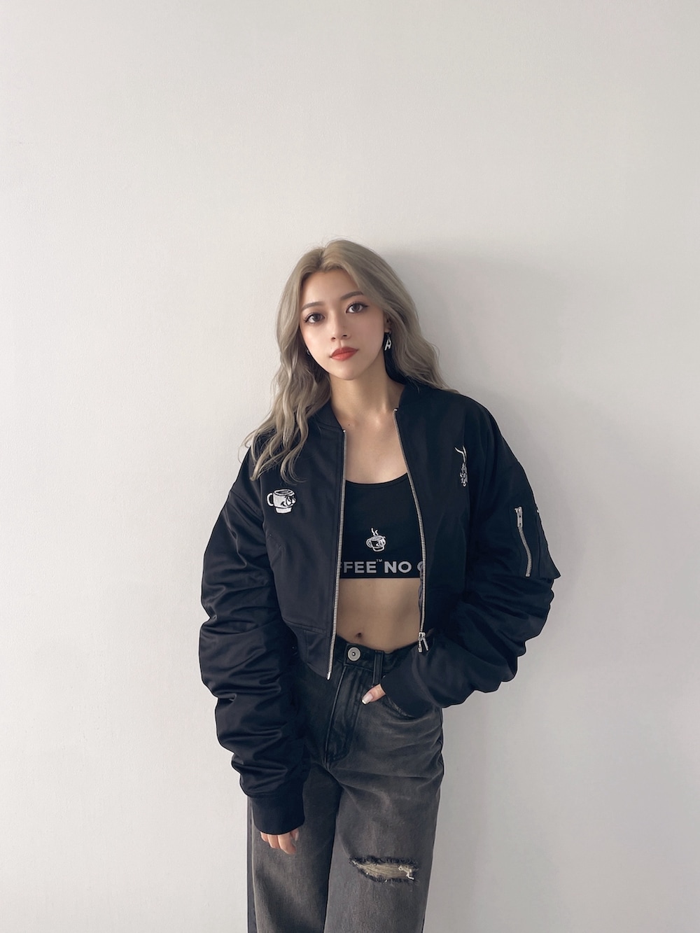 ブラック系のブルゾン、ブラック系のキャミソール、ブラック系のデニムパンツを着用したレディースの秋コーディネートの3枚目の写真