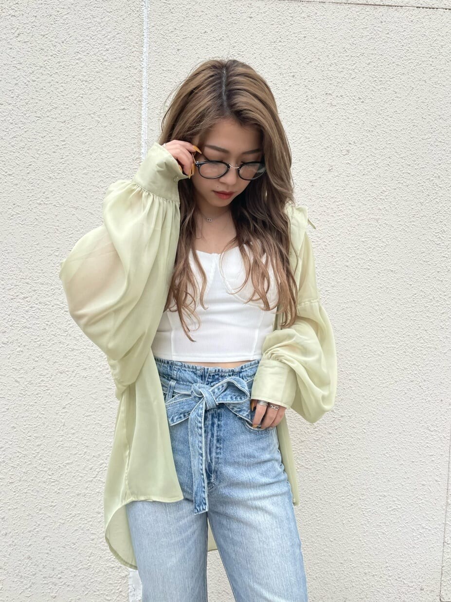 イエロー系のシャツ/ブラウス、ホワイト系のサンダル、ブルー系のデニムパンツを着用したレディースの春コーディネートの3枚目の写真