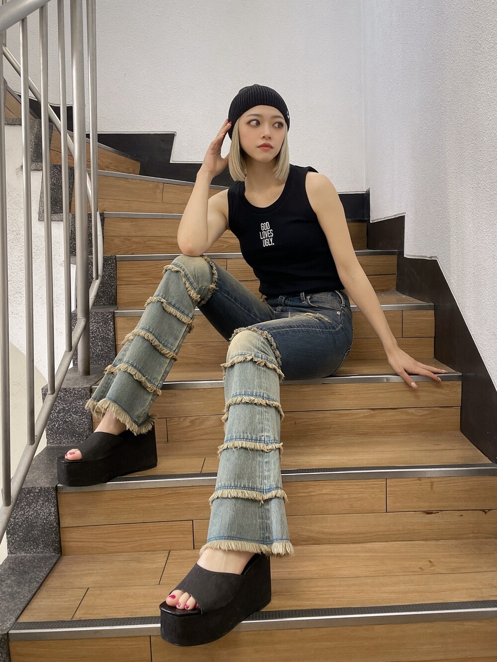 ブラック系のタンクトップ、ブルー系のデニムパンツ、ブラック系のサンダルを着用したレディースの夏コーディネートの2枚目の写真